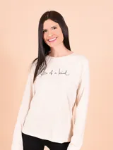 Remera de manga larga color beige con cuello redondo y estampa frontal con la frase 'One of a kind'.