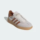 Championes Adidas Handball Spezial de diseño clásico, confeccionados en gamuza color beige con las icónicas tres tiras y refuerzo en el talón con textura de piel de serpiente en tono marrón. Presentan suela de goma color caramelo y detalles dorados en el lateral y la lengüeta.