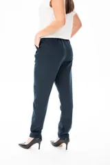 Pantalón de vestir azul marino, de corte recto, con bolsillos laterales y traseros. Se ajusta a la cintura con cinturón de cuero marrón.