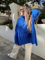 Sweater azul eléctrico de tejido de punto trenzado, cuello alto y corte oversize con aberturas laterales.