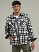 Sobrecamisa a cuadros azul, verde y blanco, con cuello camisero, cierre frontal con botones, dos bolsillos de parche con botón en el pecho y puños abotonados.