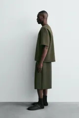 Bermuda de corte oversize confeccionada en tejido técnico compacto con elasticidad. Presenta cintura elástica ajustable con cordón, pinzas en el delantero y la espalda, y bolsillos laterales.