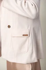 Blazer verde con corte clásico, doble botonadura y bolsillos con solapa.