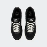 Championes New Balance Numeric 440 de estilo skate, color negro con costuras blancas visibles. Presentan el logo N en el lateral, cordones blancos y una suela de goma con entresuela color crema.