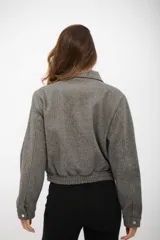 Campera tipo bomber gris de textura suave, con cuello camisero, cierre frontal completo y bolsillos laterales.