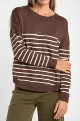 Sweater marrón con rayas horizontales blancas, de corte holgado y manga larga. Tejido suave y liviano de viscosa, poliéster y poliamida.
