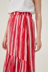 Falda midi con estampado de rayas verticales rojas y blancas, cintura elastizada y volados asimétricos en el ruedo.