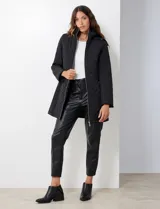 Campera capitoneada de corte largo con diseño de costuras multidireccionales, combinando un patrón de rombos en el cuerpo con capitoneado lineal en laterales y hombros. Cuenta con cierre frontal completo, cuello alto reforzado, capucha desmontable ajustable con cordones y bolsillos laterales con cierre invisible.