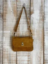 Minibag de diseño estructurado tipo acordeón, con acabado texturizado brillante en color negro. Cuenta con solapa frontal, cierre metálico giratorio y doble correa.