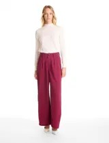 Pantalón tipo palazzo de corte ancho y fluido, confeccionado en tejido sastrero. Presenta tiro alto con doble abotonadura frontal, pinzas decorativas y cintura elástica en la parte posterior. Incluye bolsillos laterales funcionales.