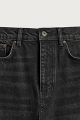 Jeans de corte recto y tiro medio, confeccionados en denim de algodón color negro con efecto deslavado y acabado rígido. Cuenta con diseño clásico de cinco bolsillos y cierre frontal con botones.