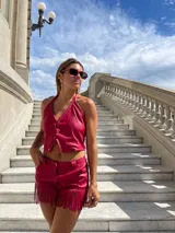 Top rojo de cuero sintético con cuello halter y cierre frontal con lazos.