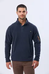 Buzo de abrigo confeccionado en tejido polar térmico, con cuello alto y cierre frontal parcial con broches. Presenta bolsillos laterales con cierre y un bolsillo adicional con cierre en la manga izquierda.