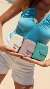 Billetera corta de símil cuero con textura croco, cierre perimetral y solapa con broche a presión. Cuenta con tarjeteros, visor, compartimento para billetes y bolsillo posterior con cierre.