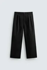 Pantalón de corte wide fit confeccionado en algodón, con pliegues frontales dobles, bolsillos laterales y bolsillos traseros de doble vivo. Presenta cierre frontal con cremallera y botón.