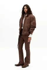 Pantalón de cuero de oveja color marrón antiguo, de corte recto, tiro medio, con elástico interno en la cintura y tajos en el ruedo.