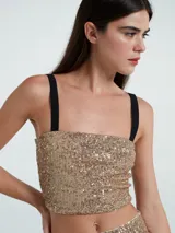 Top corto de lentejuelas doradas con escote recto y tirantes anchos negros no ajustables.