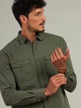 Camisa de manga larga color azul con dos bolsillos frontales con botón.