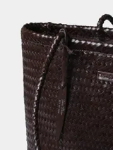 Bolso tipo shopper elaborado en cuero trenzado de color marrón, con asas de hombro trenzadas y bolsillo interior con cremallera.