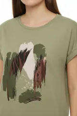 Remera de algodón blanca, de corte holgado, manga corta con vuelta y cuello redondo. Cuenta con un estampado frontal abstracto con trazos en tonos marrón y foil dorado.