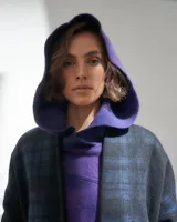 Capucha de lana merino afieltrada color uva, con capucha amplia y bolsillos frontales.