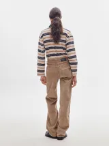 Pantalón de pana roja con corte holgado y tiro medio. Presenta una línea dorada a lo largo de la pierna.