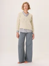 Buzo de lana color marrón topo, con cuello en V y diseño de punto calado en rombos en el frente y mangas.