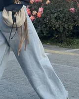 Bandolera pequeña de cuero vacuno color beige con detalles de flecos de cuero.