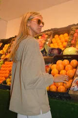 Canguro beige de tejido waffle con capucha, mangas largas y cierre parcial con botones.