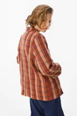 Blazer de corte recto con estampado de cuadros en tonos marrones, beige y rojos. Presenta solapas clásicas, cierre frontal con un botón y bolsillos laterales con solapa.