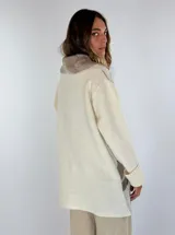 Saco de lana color verde militar con estampado abstracto en tonos verde oliva y detalles bordados en rojo. Tiene cuello solapa, cierre frontal con botones de madera y puños acanalados.