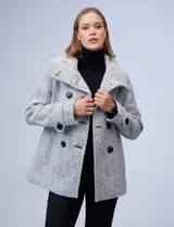 Tapado corto de lana y poliéster, con tejido tweed en tonos blanco y negro. Presenta cuello con solapa, doble abotonadura frontal en color negro y bolsillos verticales.