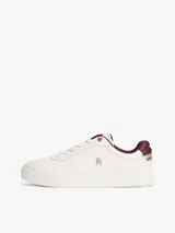 Zapatillas de cuero estilo tenis, color blanco, con cordones y suela de goma al tono. Presentan forro interior en color bordó, ojal superior metálico dorado y logo de monograma TH metálico en el lateral.