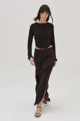 Top tejido en lurex y viscosa, color marrón oscuro, de manga larga, con espalda cruzada y mini volados en los puños.