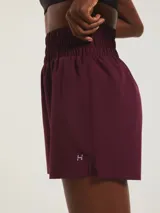 Short deportivo de corte runner con cintura elástica alta y fruncida, confeccionado en tejido técnico de secado rápido.