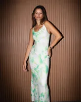 Vestido largo de diseño ceñido con estampado tie-dye en tonos verdes y blancos. Cuenta con escote tipo buche y finos tirantes.
