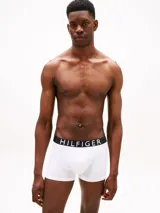 Pack de tres calzoncillos tipo trunk de algodón elástico. Cada uno presenta una cintura elástica distintiva con el logo de Tommy Hilfiger en contraste.