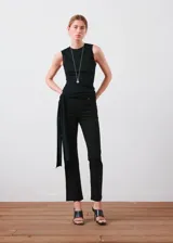 Jeans de denim elástico color negro, tiro medio, diseño crop y estilo flare con cierre delantero de cremallera y botón, trabillas y cinco bolsillos.