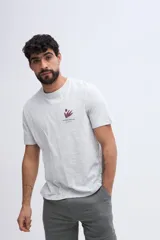 Remera de algodón color gris melange, de ajuste regular, manga corta, con cuello redondo y estampa pequeña en el pecho.