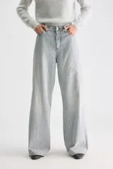 Pantalón jean de tiro medio y corte holgado con pernera ancha, diseño a rayas verticales celestes y blancas, confeccionado en algodón rígido.