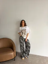 Remera oversize de algodón negro, con diseño gráfico frontal que incluye la leyenda "COFFEE CLUB" y una ilustración estilo retro de una mujer bebiendo café.