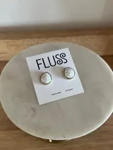 Aros tipo stud marca Fluss, hechos a mano con perlas de río engarzadas en una base metálica.