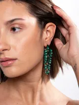 Aros colgantes largos con diseño de hojas o cascada, compuestos por múltiples cristales facetados de color verde esmeralda y estructura dorada.
