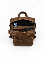 Mochila de cuero marrón, con compartimento principal amplio, bolsillo frontal con cierre y tiradores metálicos. Cuenta con correas regulables y diseño apto para notebook.