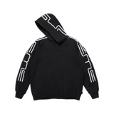 Campera canguro Supreme de color negro con cierre frontal completo y capucha. Presenta diseño estampado de líneas blancas que forman la palabra Supreme a lo largo de las mangas y sobre la capucha, además de bolsillos tipo canguro en la parte frontal.