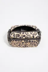 Bolso bandolera Bimba y Lola de tamaño pequeño, confeccionado en nylon con estampado animal print. Presenta estructura blanda, asa regulable de tejido negro, cierre principal con cremallera y bolsillos laterales con cierre.
