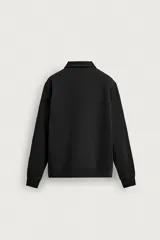 Sudadera polo de corte regular, confeccionada en tejido técnico interlock de algodón con elasticidad. Presenta cuello solapa, cierre frontal de cremallera y manga larga con puños acabados en rib.