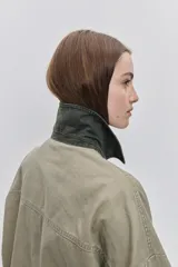 Campera de gabardina tostada, con cuello camisero de pana marrón, cierre frontal de botones metálicos y bolsillos delanteros aplicados con solapa.