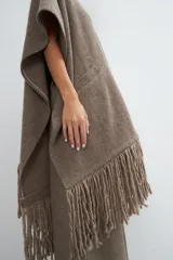 Ruana marrón con flecos y bolsillos. Terminaciones envivadas.