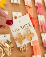 Aros colgantes con forma de flor color durazno con borde dorado.